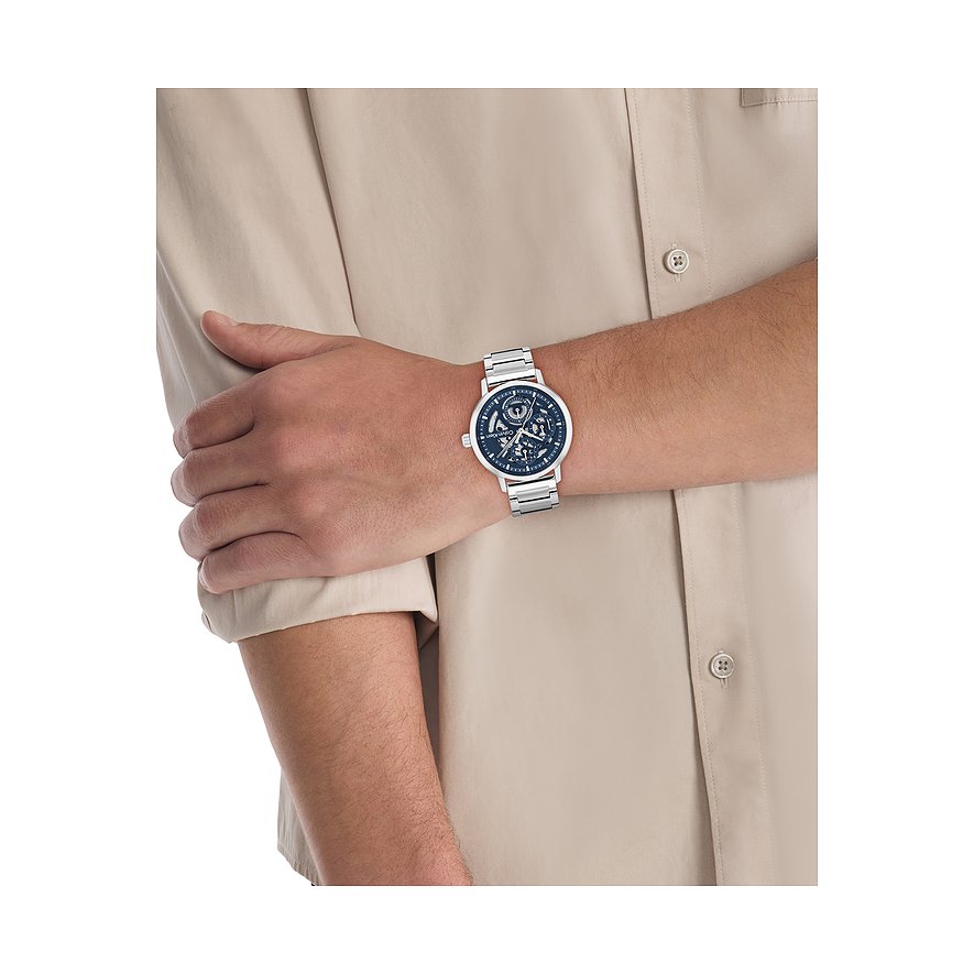 Am Handgelenk eines Mannes getragene Calvin Klein Herrenuhr aus Edelstahl mit blauem Zifferblatt und silbernem Armband.