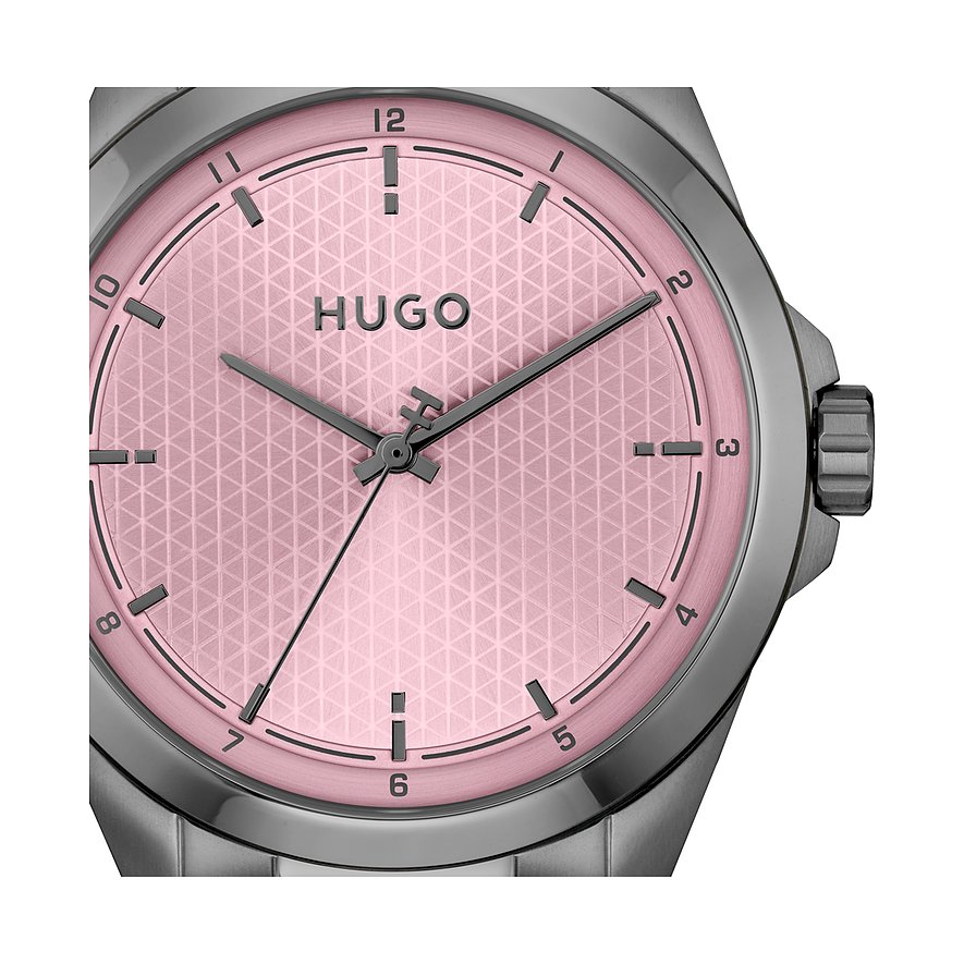 Close-up van een Hugo herenhorloge van roestvrij staal met een roze wijzerplaat en fijn geometrisch patroon.