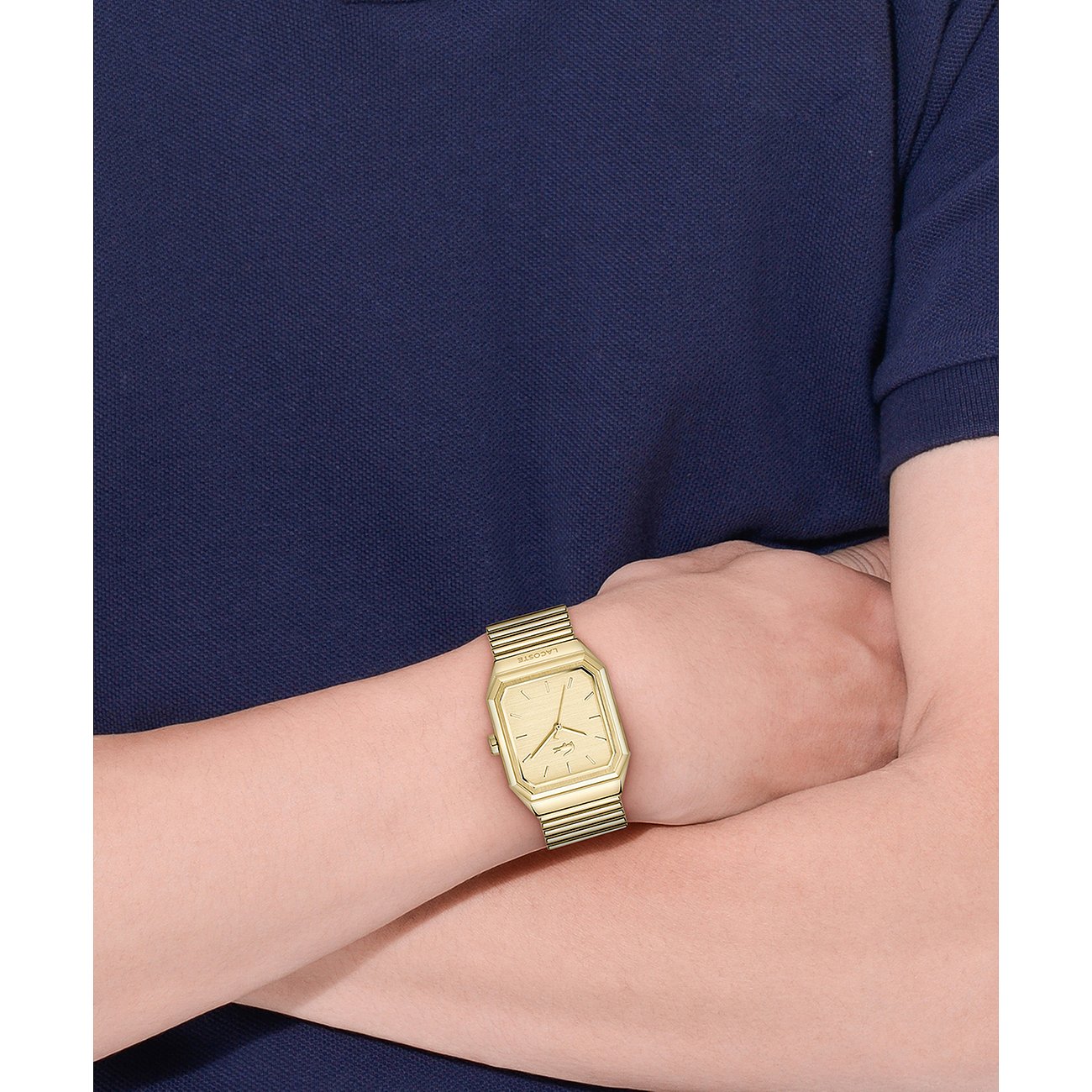 Nahaufnahme einer goldenen Lacoste Herrenuhr aus Edelstahl an einem Handgelenk, die Uhr zeigt 10:10 Uhr.