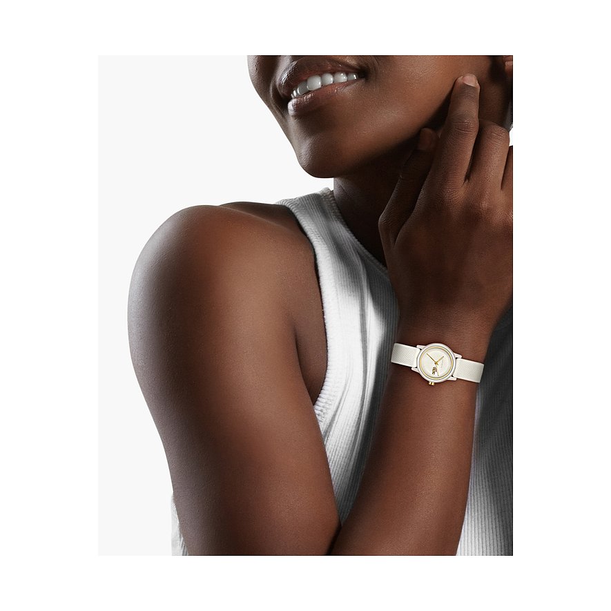 Nahaufnahme eines Lacoste Aluminium Damenuhren-Zifferblatts mit weißem Armband, getragen an einem Handgelenk.