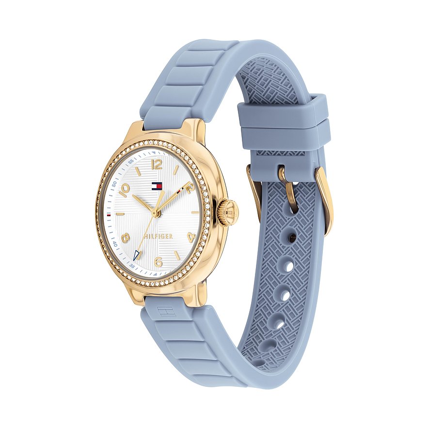 Tommy Hilfiger Damenuhr aus goldfarbenem Edelstahl mit hellblauem Silikonarmband und Besatz aus klaren Schmucksteinen.