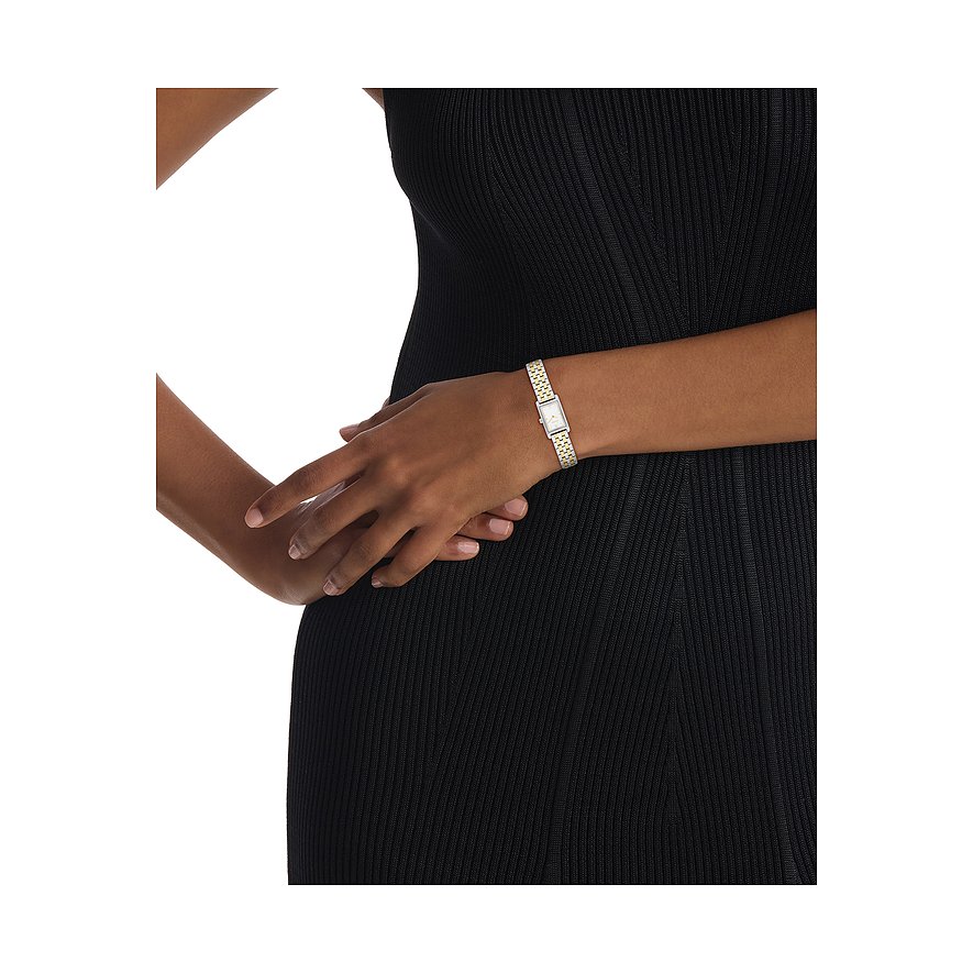 Am Handgelenk einer Person mit schwarzem Kleid ist eine Calvin Klein Damenuhr aus Edelstahl mit eckigem Zifferblatt zu sehen.