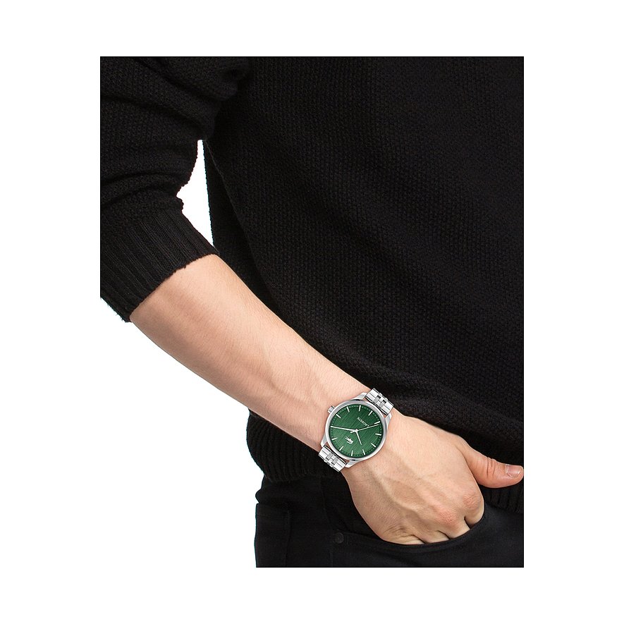 Am Handgelenk eines Mannes wird eine Lacoste Herrenuhr aus silberfarbenem Edelstahl mit schwarzem Zifferblatt getragen.