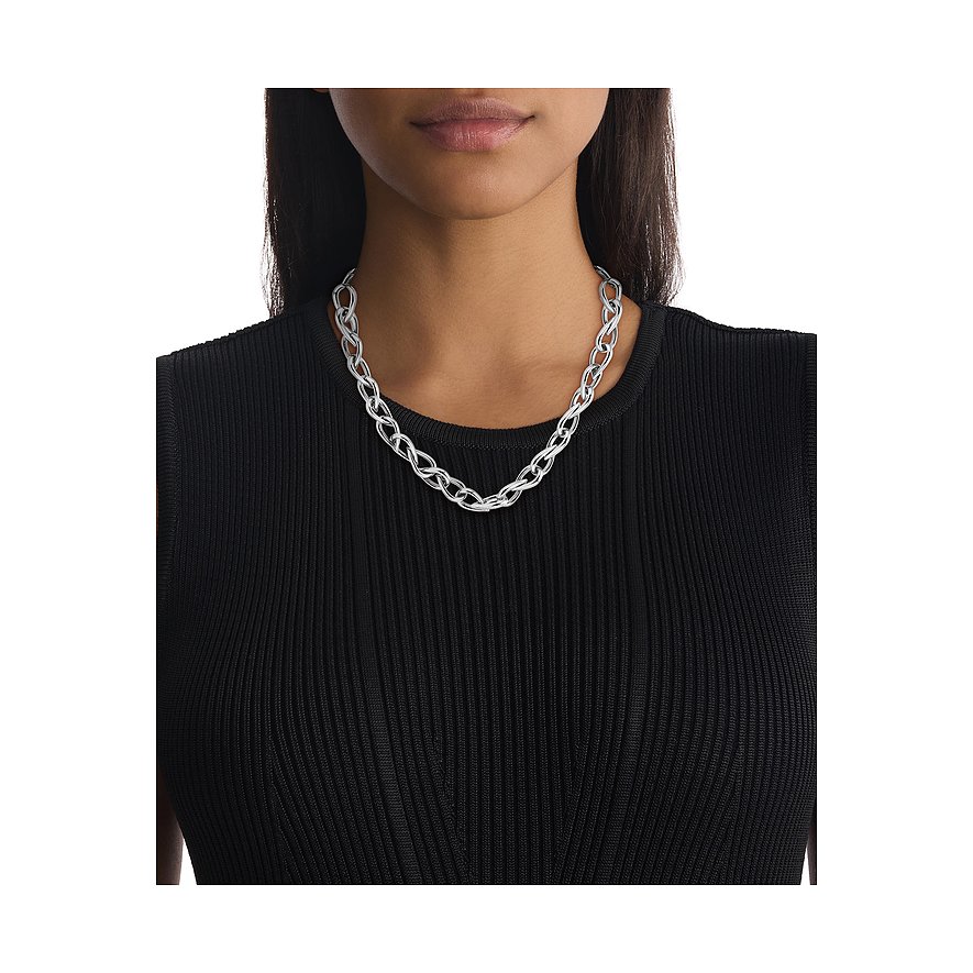 Een glanzende roestvrijstalen Calvin Klein ketting met in elkaar verstrengelde schakels. Een vrouw draagt de ketting.