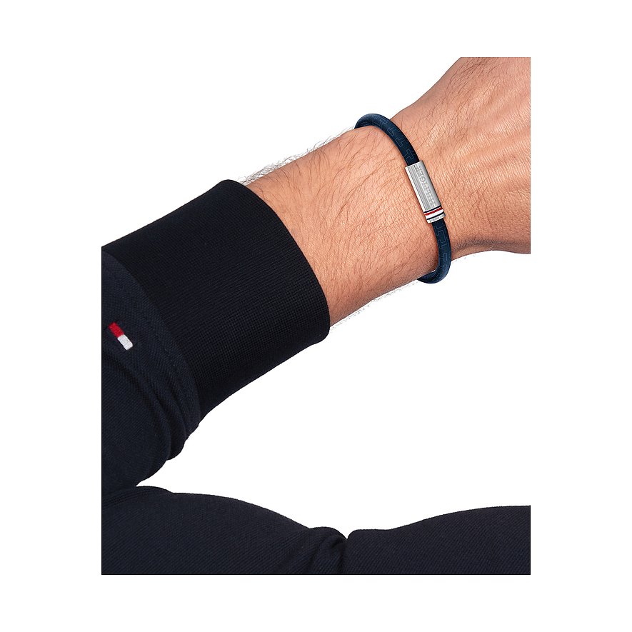 Ein Mann trägt ein blaues Tommy Hilfiger Armband aus Edelstahl mit einem silbernen Verschluss am Handgelenk.