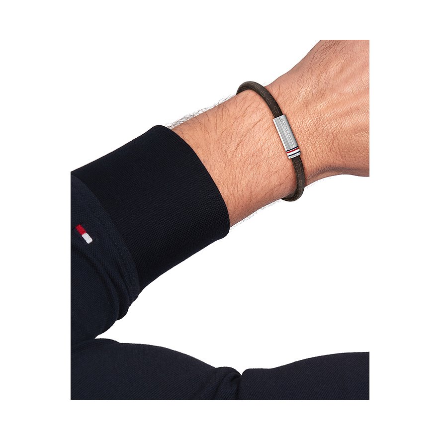 Ein Tommy Hilfiger Armband aus dunkelbraunem Leder ist am Handgelenk eines Mannes zu sehen.