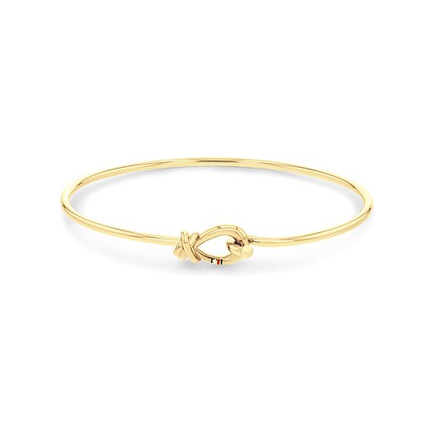 Ein zartes Tommy Hilfiger Armband aus goldfarbenem Edelstahl, das einen dekorativen Knoten als Verschluss hat.