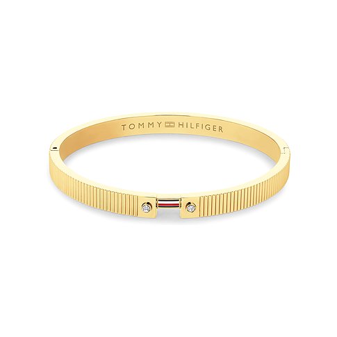 Tommy Hilfiger Armreif aus goldfarbenem Edelstahl mit Tommy Hilfiger Logo, zwei Kristallen und Rillenmuster.