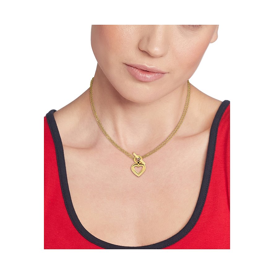 Eine Frau trägt eine Tommy Hilfiger Halskette aus goldfarbenem Edelstahl mit einem Herzanhänger.