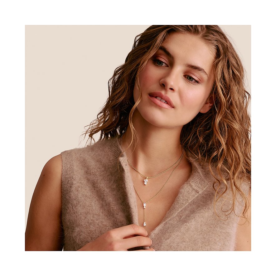 Eine Frau trägt zwei Thomas Sabo Ketten aus Silber, eine mit einem einzelnen Zirkonia-Anhänger, die andere als Y-Kette.