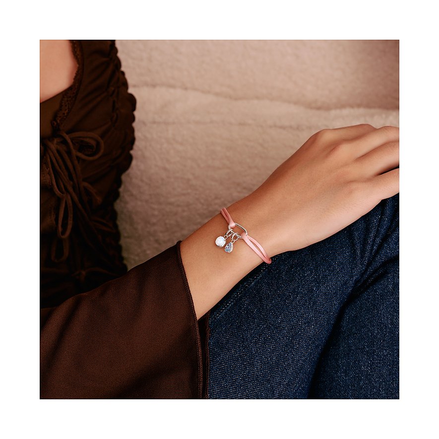 Al polso di una persona, un bracciale Thomas Sabo in tessuto color oro rosa e argento con due ciondoli.