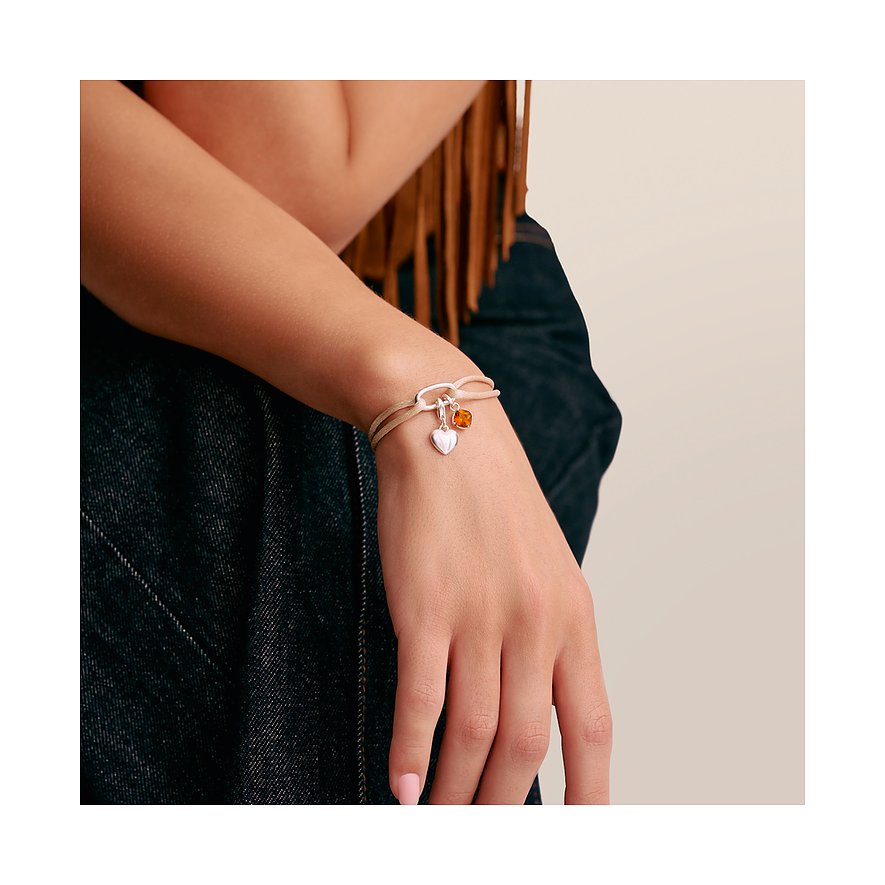 Bracciale Thomas Sabo in argento al polso con pendente a cuore e charm arancione.
