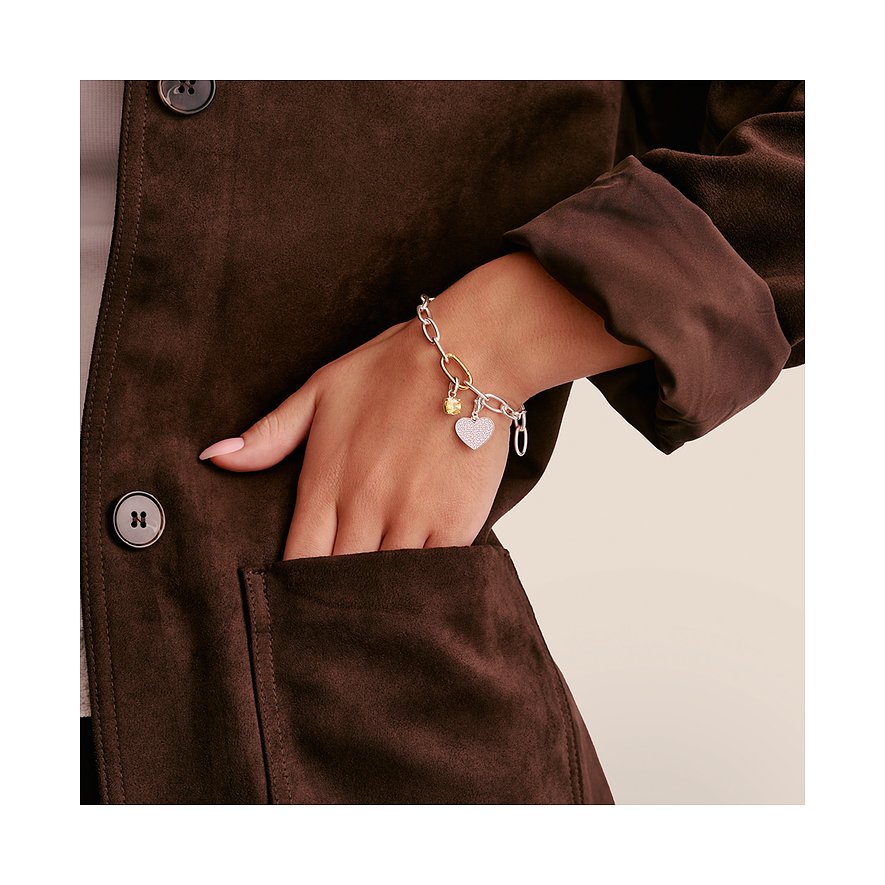 Bracciale charm Thomas Sabo argento con zirconia, ciondolo a cuore e zirconia gialla al polso.