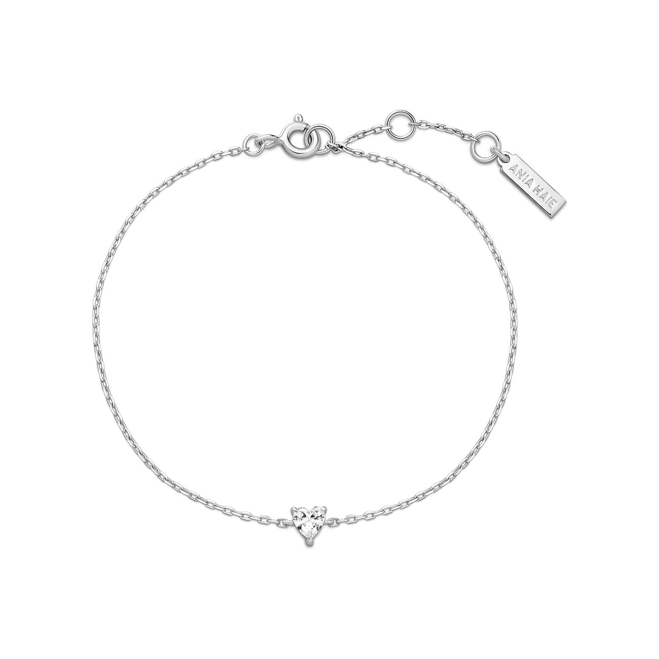 Ania Haie zilveren armband met een hartvormige zirkonia in het midden, die het licht reflecteert.