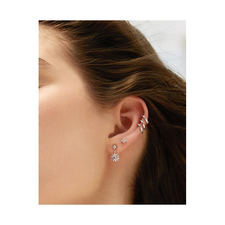 Nærbillede af et øre med Ania Haie øresmykker i 925 sterlingsølv med zirkonia-farvede sten og ear cuffs.