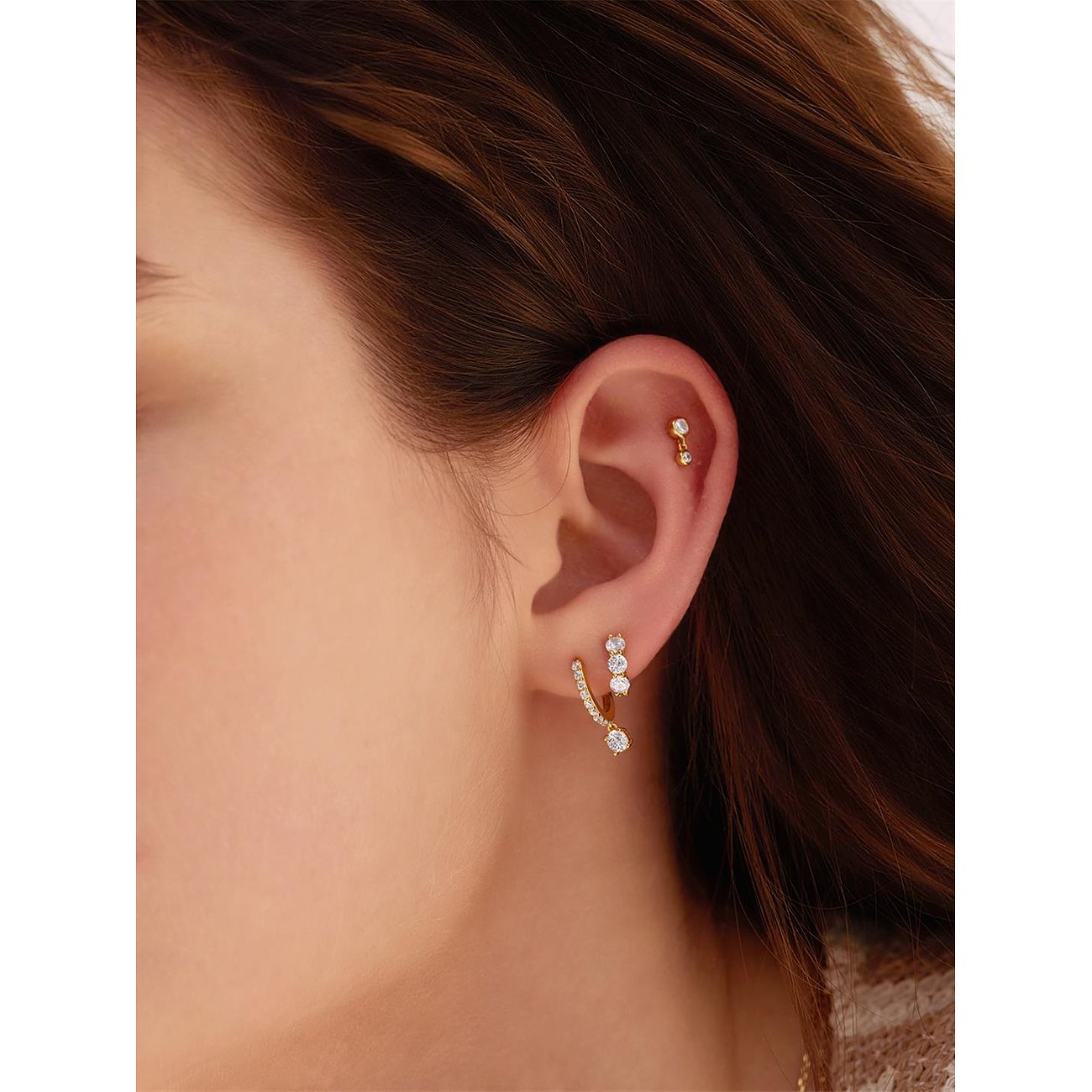 Ania Haie Ohrring aus 925er Silber mit Zirkonia-Steinen am Ohr, ein weiteres Piercing in der Helix.