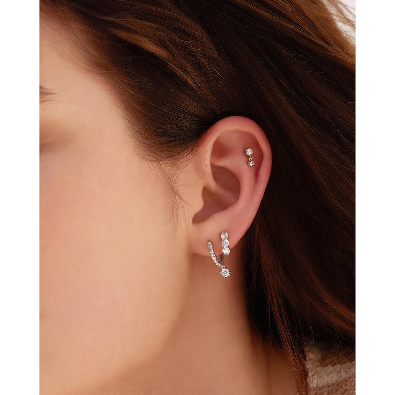 Am Ohr einer Person ist ein Ania Haie Ohrring aus 925er Silber mit Zirkonia-Farbsteinen zu sehen.