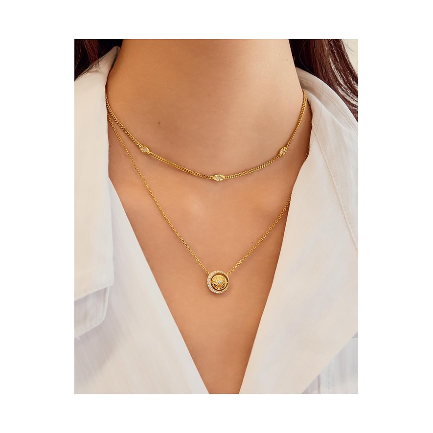 Vrouw draagt twee Ania Haie kettingen: een gouden choker en een gouden ketting met ronde zirkonia hanger.