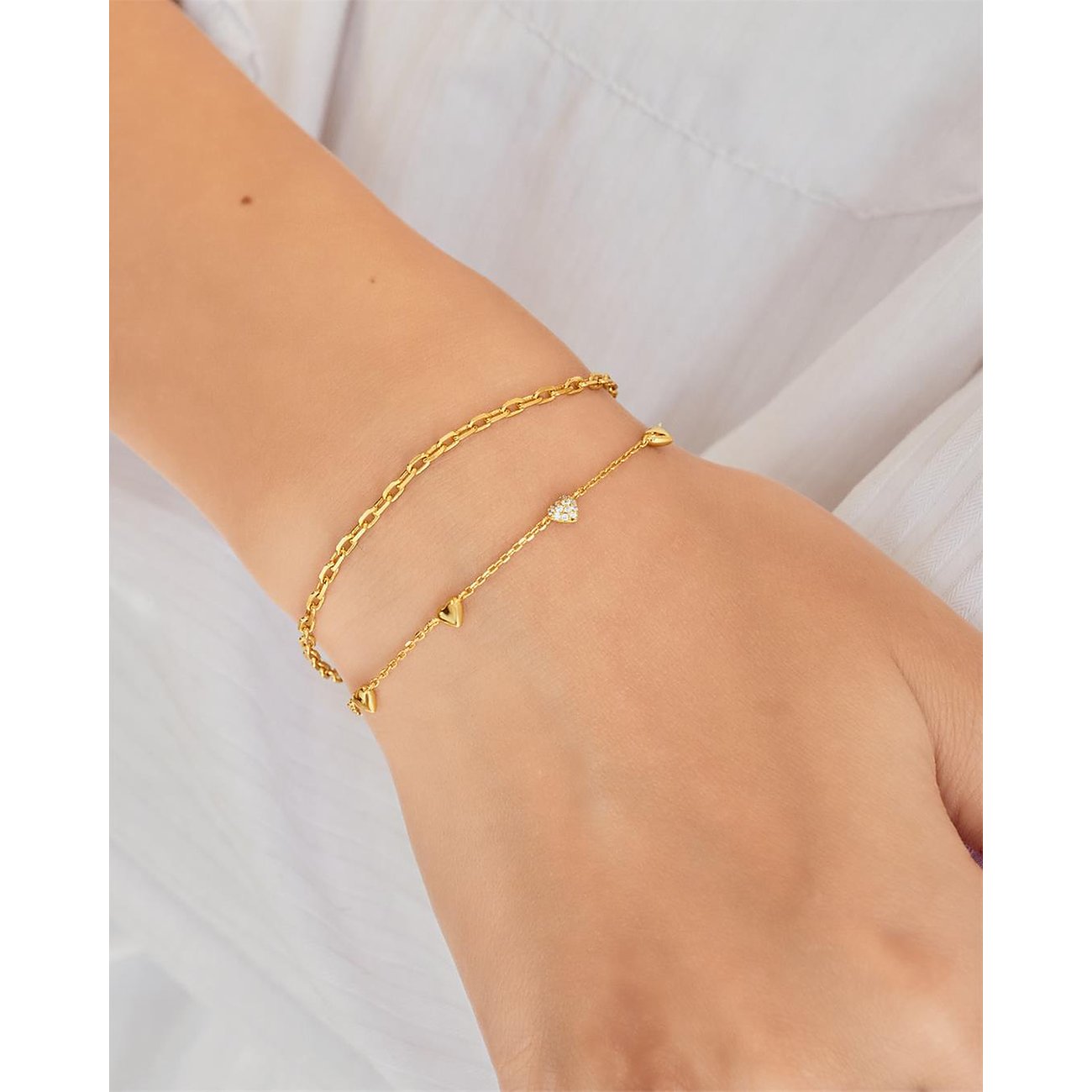 Bracciale Ania Haie d'argento indossato al polso, con zirconia e cuori stilizzati.