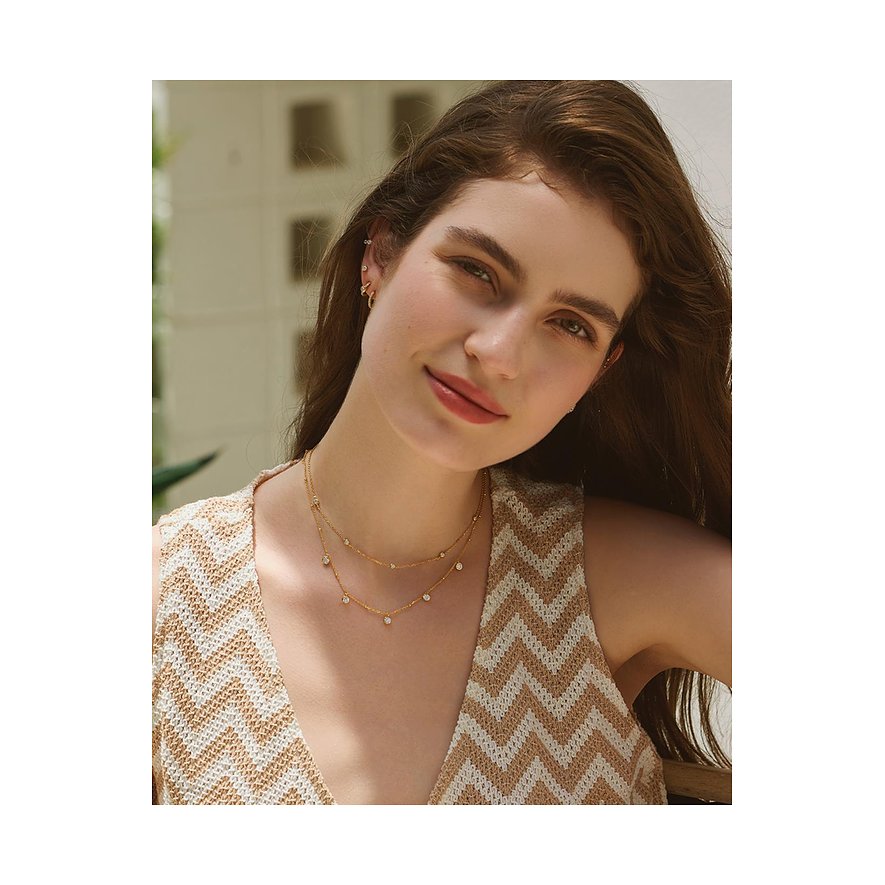 Een model draagt een glanzend gouden, dubbele Ania Haie zilveren halsketting met gekleurde zirkoniasteentjes.