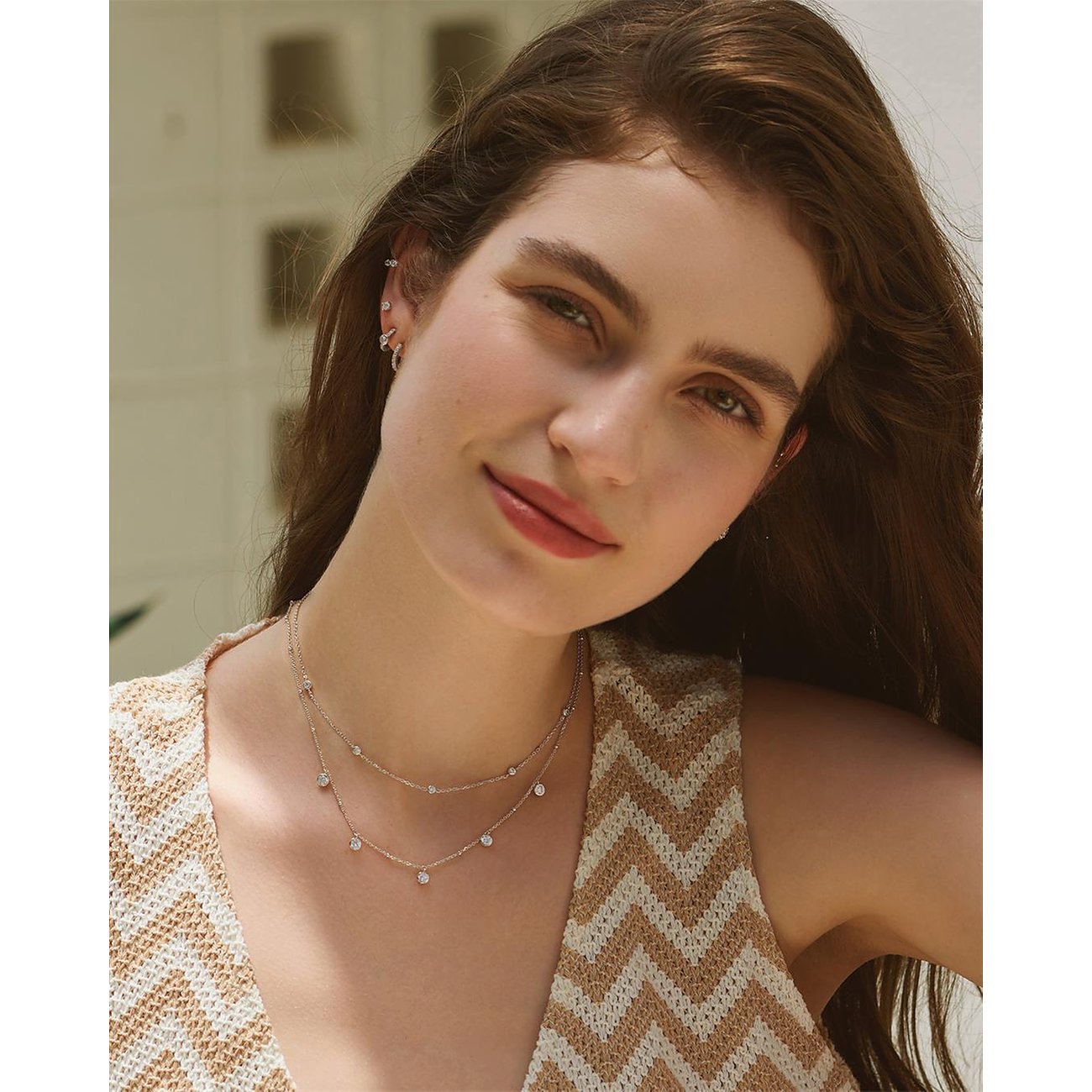 Close-up portret van vrouw met een dubbelrijige zilveren Ania Haie halsketting met zirkonia-elementen.