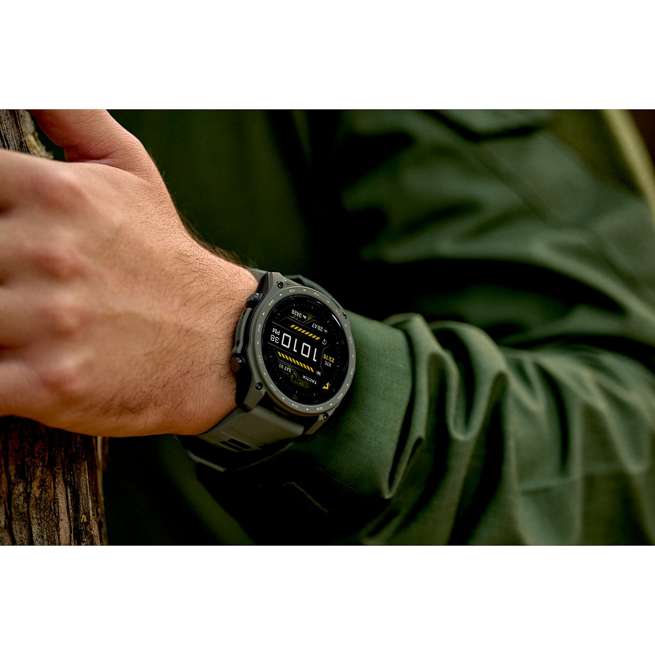 Nahaufnahme einer Garmin Smartwatch aus Titan am Handgelenk eines Mannes, der auf einem Baumstamm ruht.