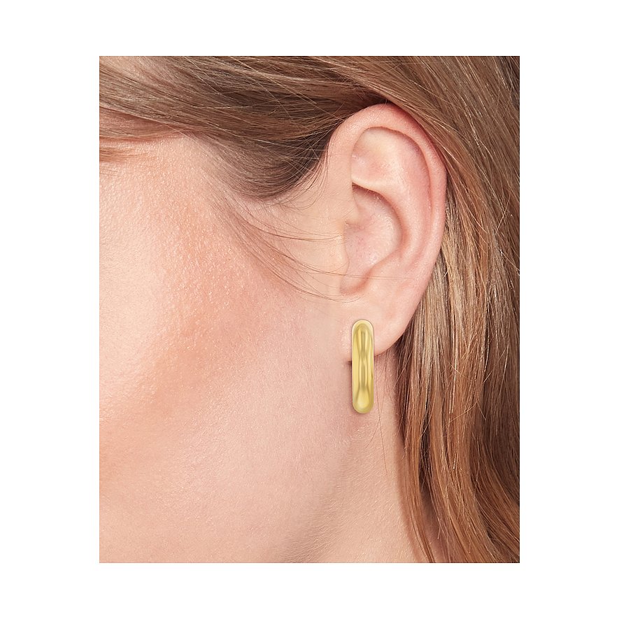 Tommy Hilfiger goldener Ohrring aus Edelstahl am Ohr einer Person, der wie eine längliche, glänzende Kapsel geformt ist.
