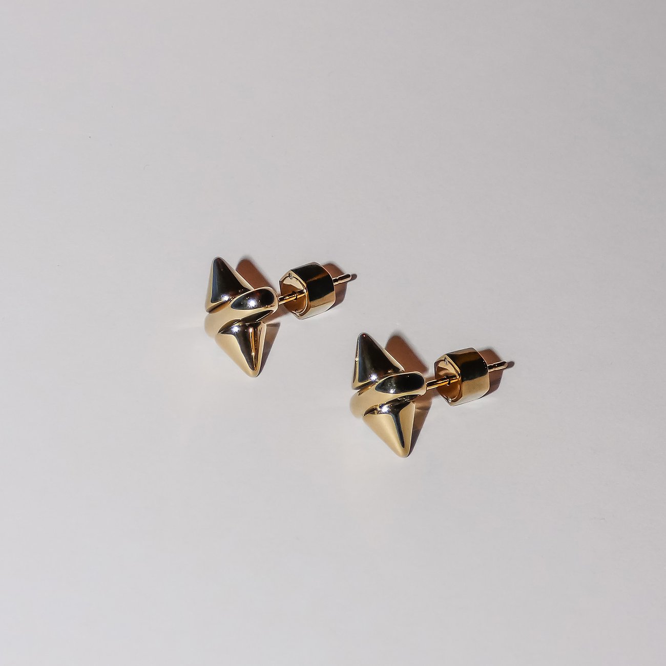 Ein Paar goldfarbener Liebeskind Ohrstecker aus Edelstahl, die eine Stachelform haben.
