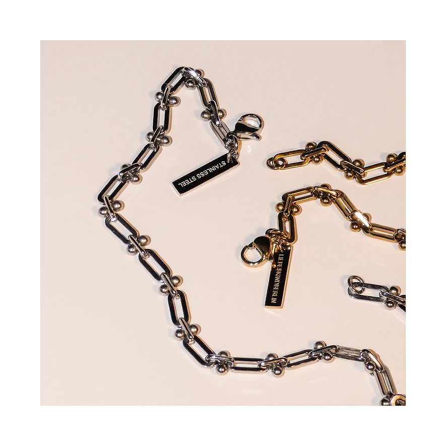 Zwei Liebeskind Armreifen aus Edelstahl, einer in Silber und der andere in Gold, beide mit Kettengliedern und kleinen Kugeln.
