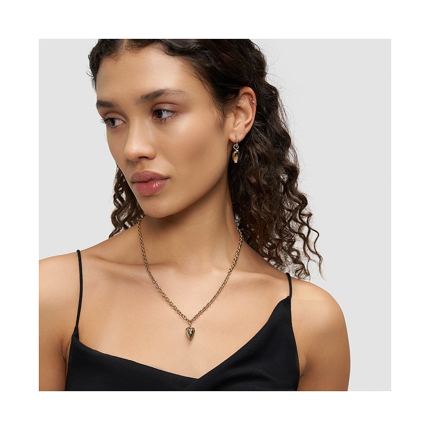 Model draagt een korte Liebeskind halsketting van goudkleurig roestvrij staal met hartje, voor een witte achtergrond.