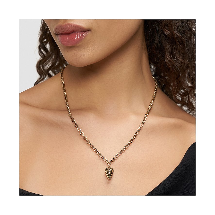 Close-up van een vrouw met een Liebeskind goudkleurige roestvrijstalen ketting met hartjeshanger.