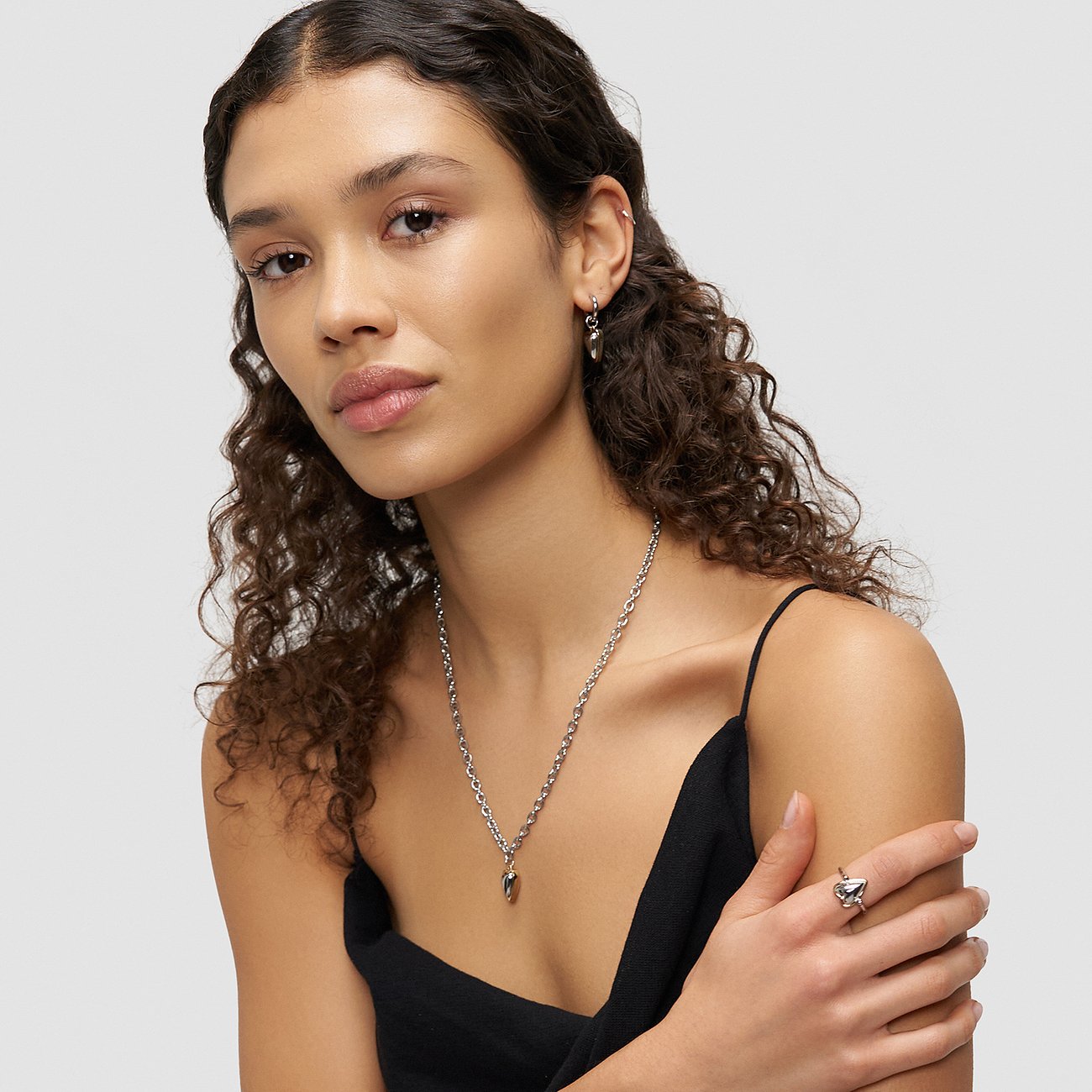 Een model presenteert een Liebeskind roestvrijstalen ketting met druppelvormige hanger en bijpassende oorbellen.