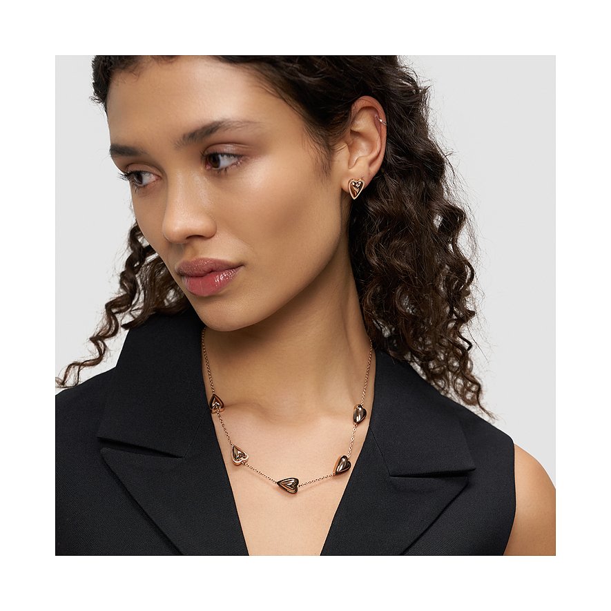 Een model draagt een Liebeskind ketting van roségoudkleurig roestvrij staal met hartvormige hangers.
