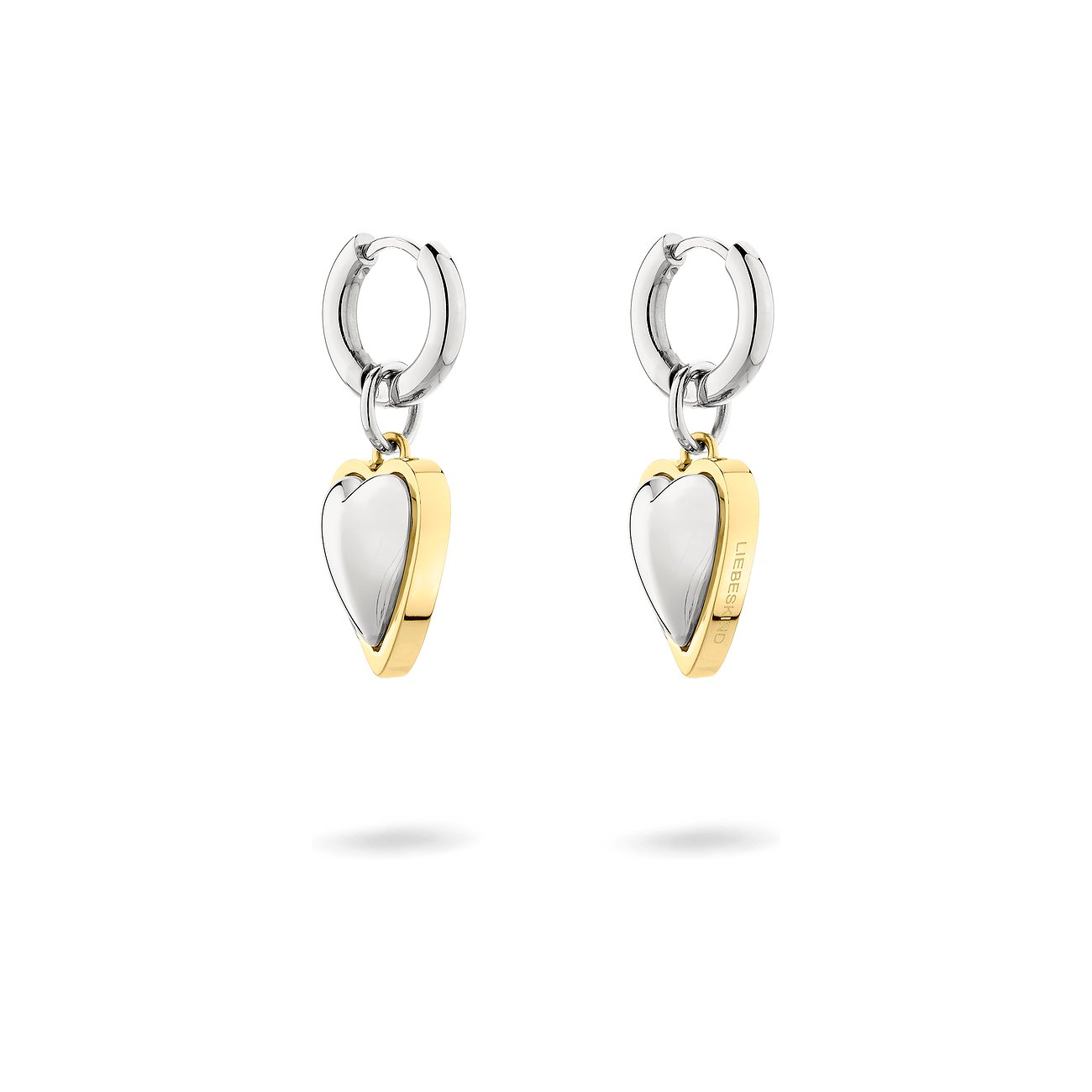 Ein Paar Liebeskind Ohrschmuck aus Edelstahl mit herzförmigen Anhängern. Die Herzen sind silbern mit goldener Umrandung.