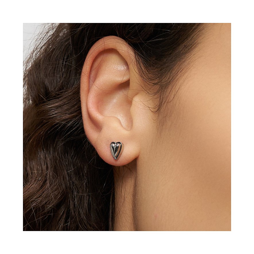 Nahaufnahme eines Ohres, das einen kleinen, herzförmigen Ohrstecker aus Edelstahl von Liebeskind trägt.