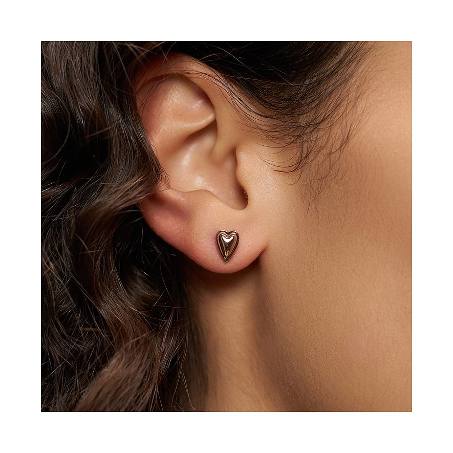 Nahaufnahme: rechtes Ohr eines Models mit herzförmigem Liebeskind Ohrstecker aus rosegoldfarbenem Edelstahl.