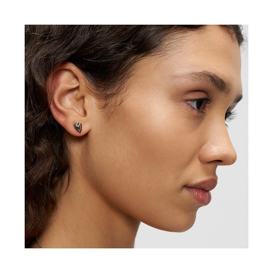 Nahaufnahme einer Person mit einem kleinen, glänzenden, herzförmigen Ohrstecker aus Liebeskind Edelstahl am rechten Ohr.