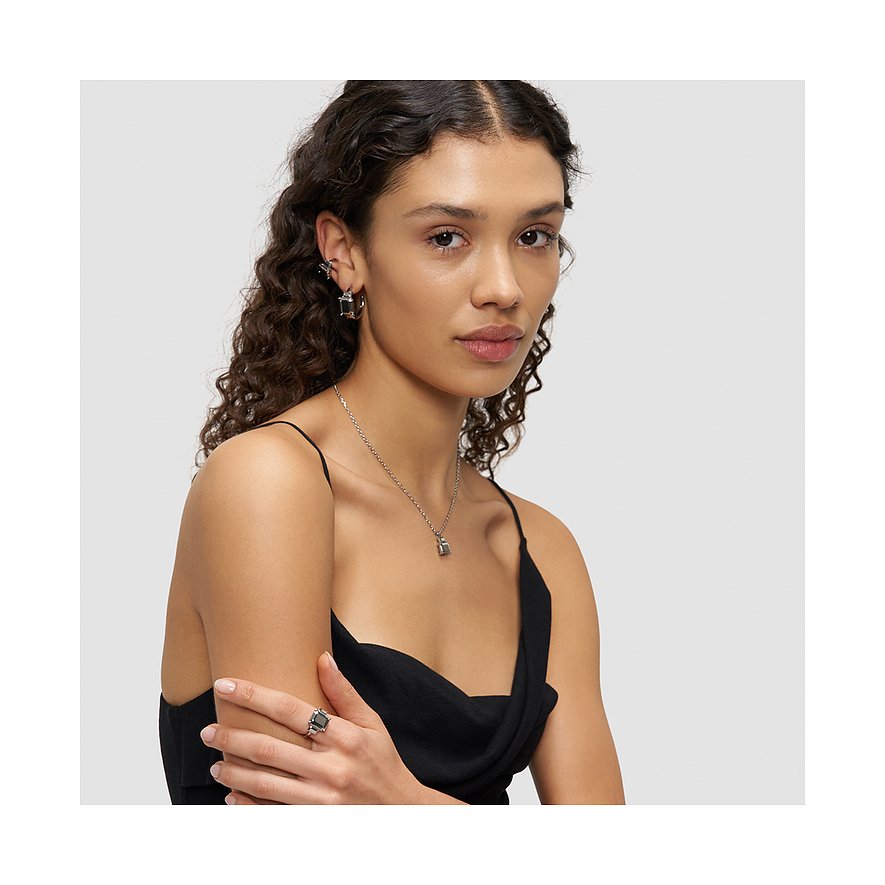 Model trägt Liebeskind Ohrschmuck aus Edelstahl, der stilvolle Creolen und einen Stern-Ohrstecker kombiniert.
