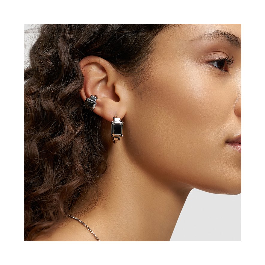 Am weiblichen Ohr getragener Ohrschmuck von Liebeskind aus Edelstahl mit schwarzer Steinoptik in rechteckiger Form.