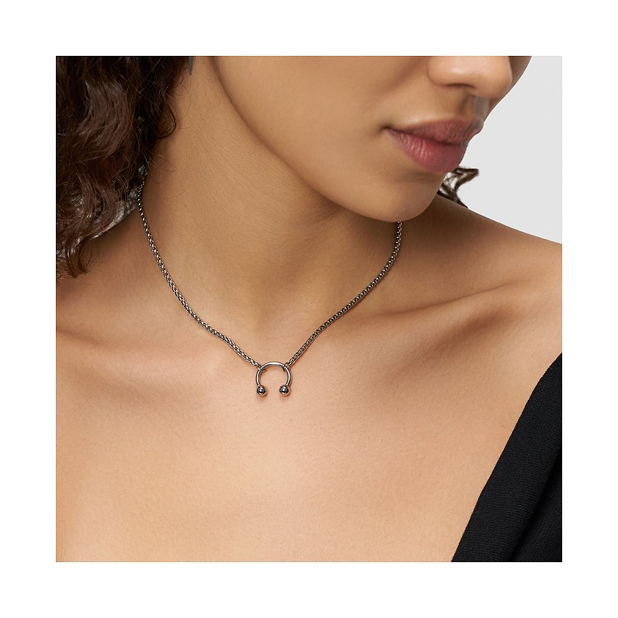 Eng anliegende Liebeskind Halsschmuck-Kette aus Edelstahl mit schlichtem Hufeisen-Anhänger am Hals einer Person.