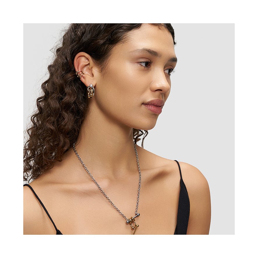 Eine Frau trägt Liebeskind Ohrschmuck aus Edelstahl, bestehend aus goldenen und silberfarbenen Ohrringen und einem Ear Cuff.