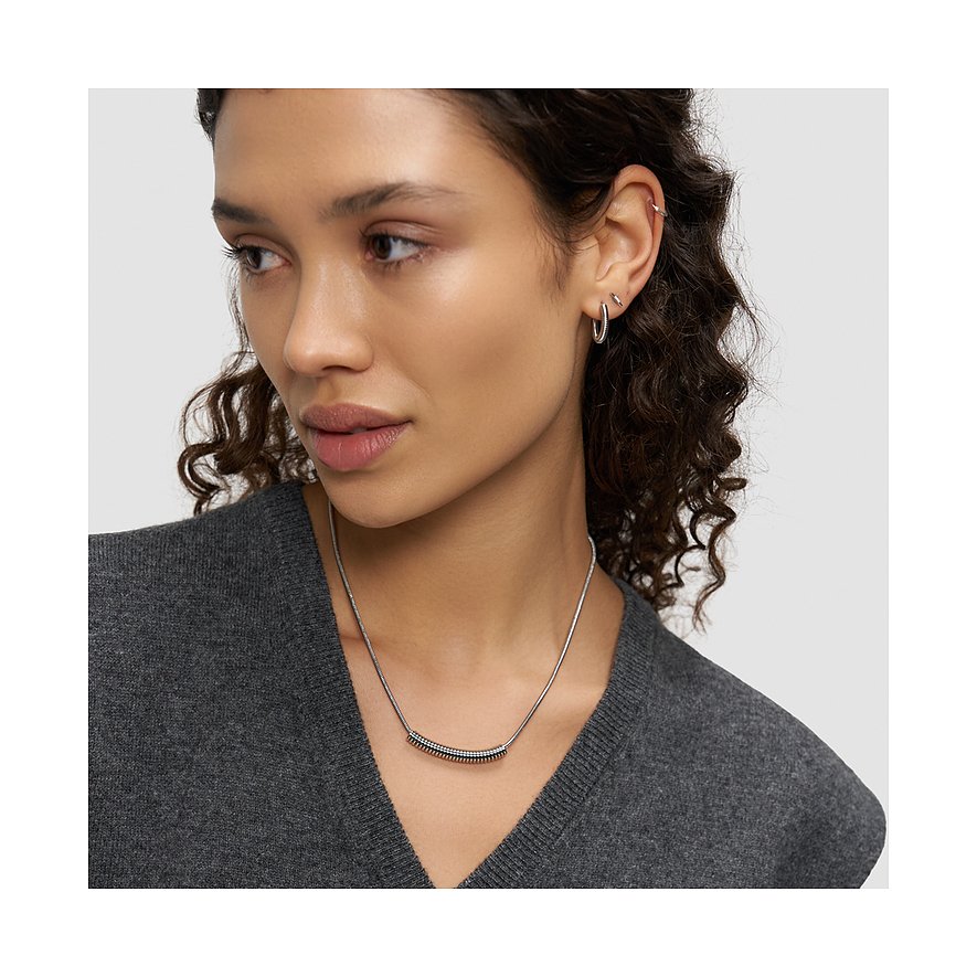 Close-up van een vrouw met een Liebeskind tweekleurige roestvrijstalen ketting, bestaande uit een smalle keten.