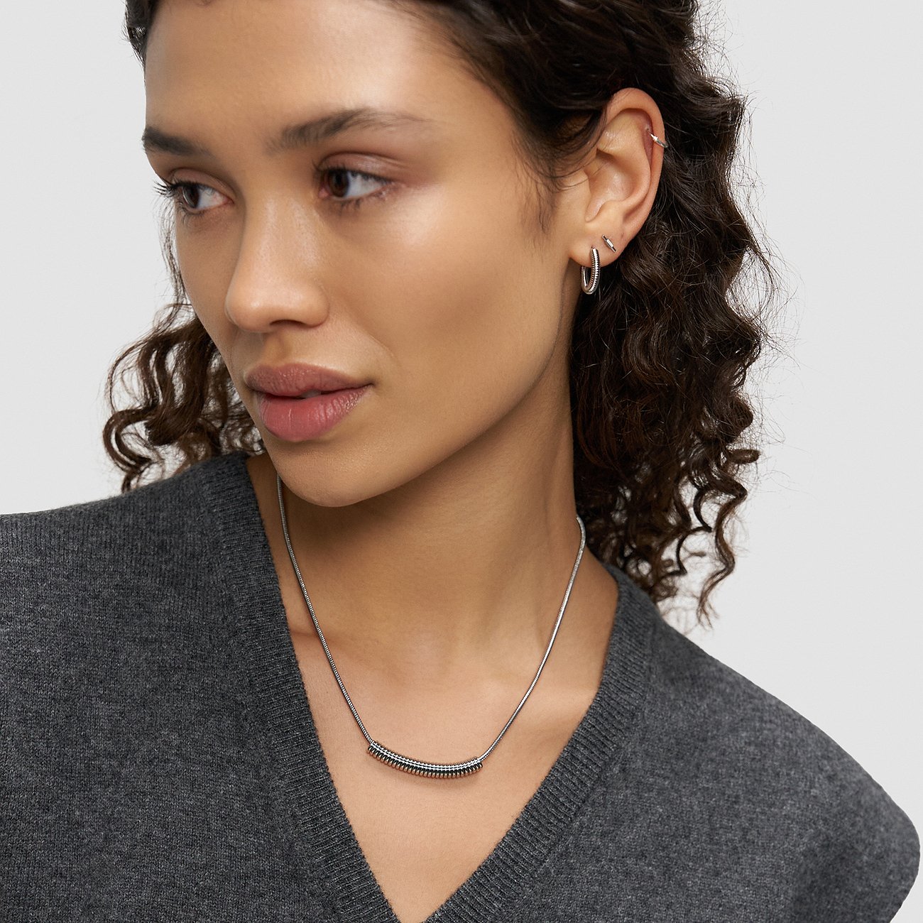 Close-up van een vrouw met een Liebeskind tweekleurige roestvrijstalen ketting, bestaande uit een smalle keten.