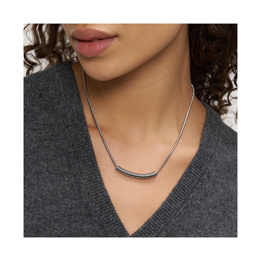 Close-up van een vrouw met een Liebeskind roestvrijstalen ketting met een horizontale buis.