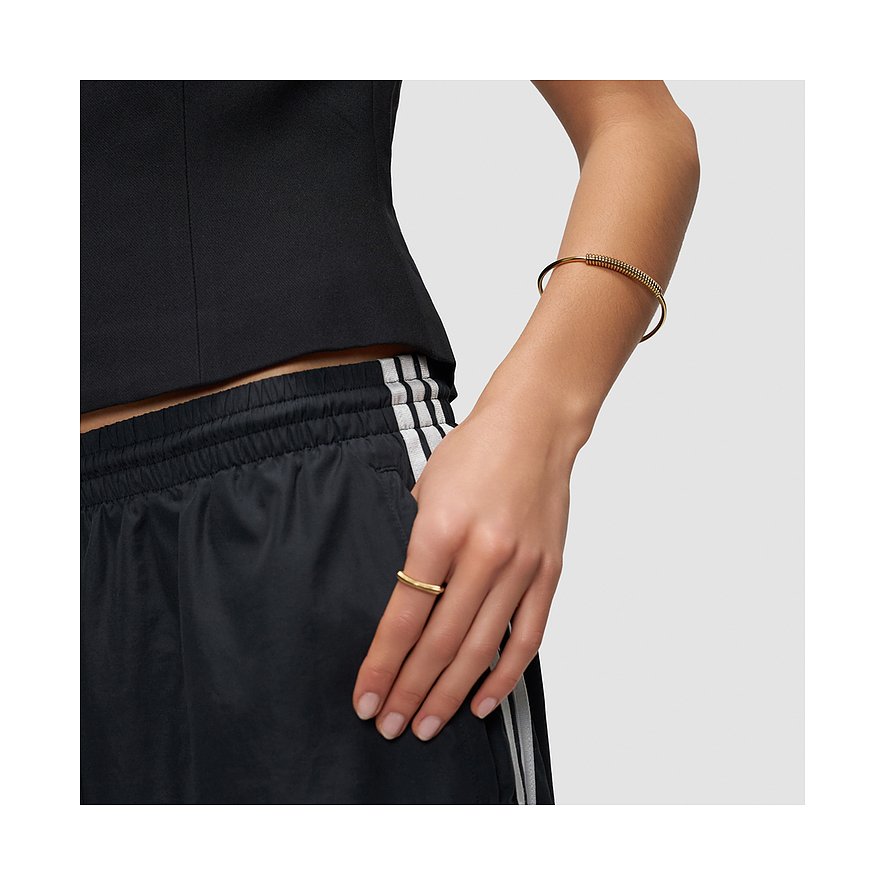 Aan de pols van een vrouw is een goudkleurige Liebeskind RVS armband met gedraaide elementen.