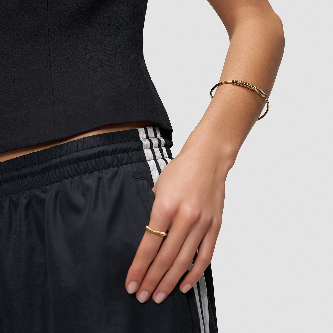 Aan de pols van een vrouw is een goudkleurige Liebeskind RVS armband met gedraaide elementen.