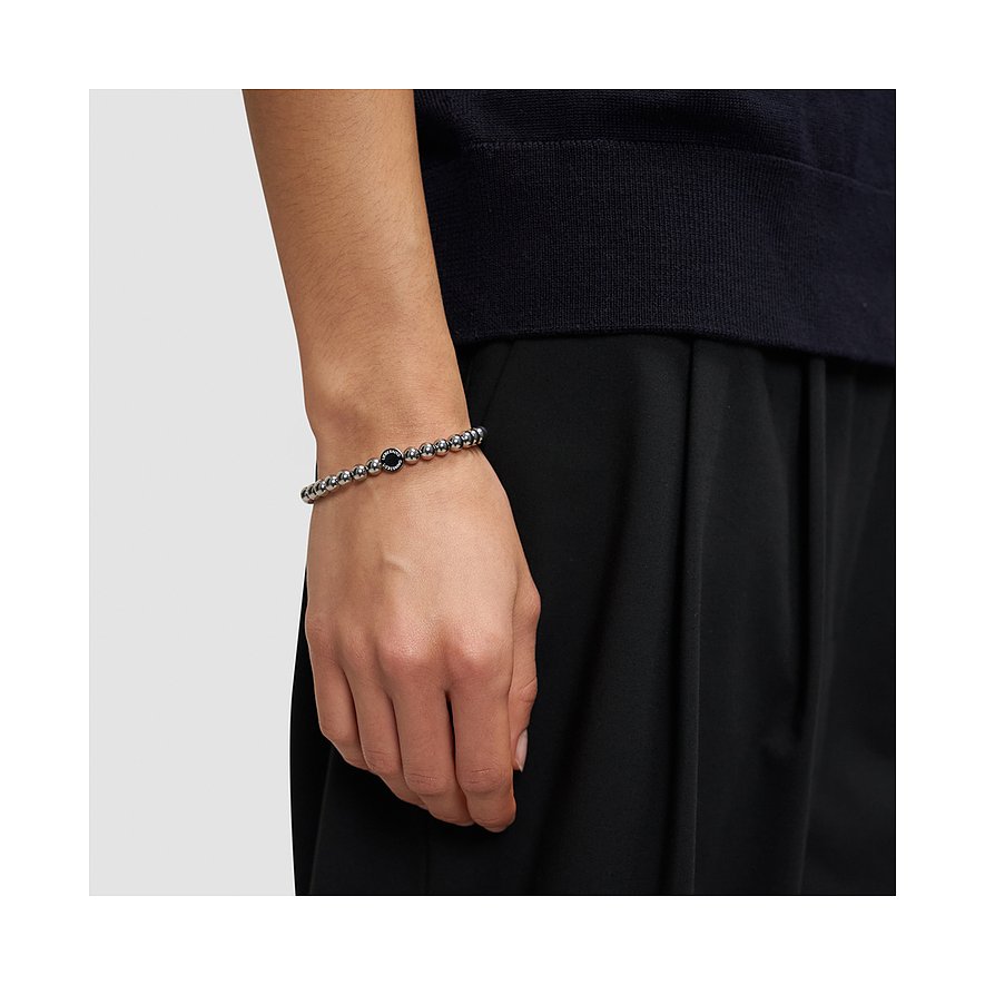 Liebeskind armband i rostfritt stål med glänsande kulor och ett svart mittelelement, buret på en handled.