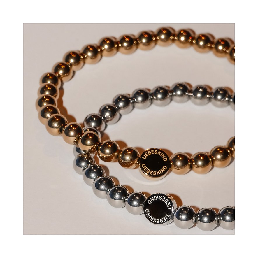 Två Liebeskind-armband i rostfritt stål med små kulor, ett guldfärgat och ett silverfärgat.