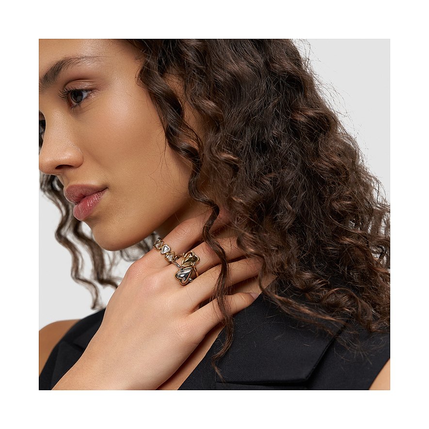 Nahaufnahme einer Frau im Profil, die einen doppelten Liebeskind Ring aus Bicolor-Edelstahl mit Herzdetail trägt.
