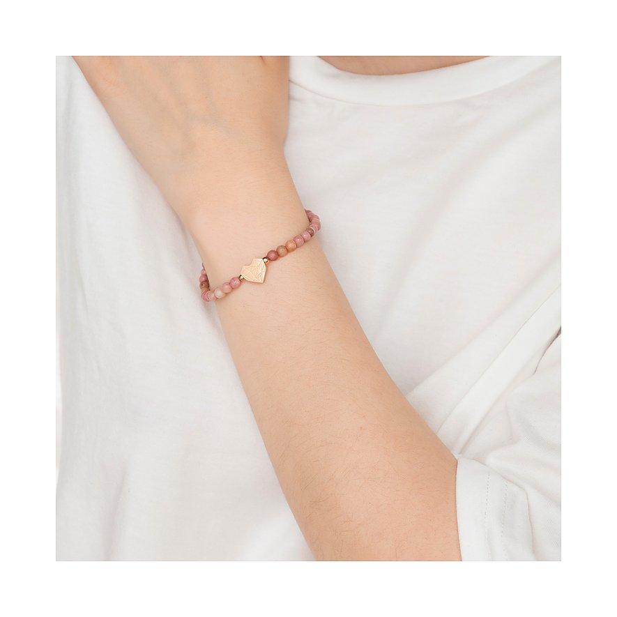 Ein Armschmuck von Liebeskind, bestehend aus mattrosa Steinperlen mit einem Anhänger aus goldfarbenem Edelstahl in Herzform.